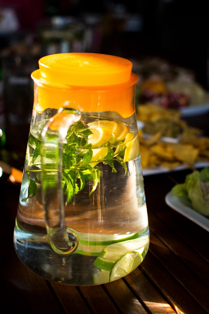 Krug mit Zitronen-Minz-Wasser im Sonnenlicht
