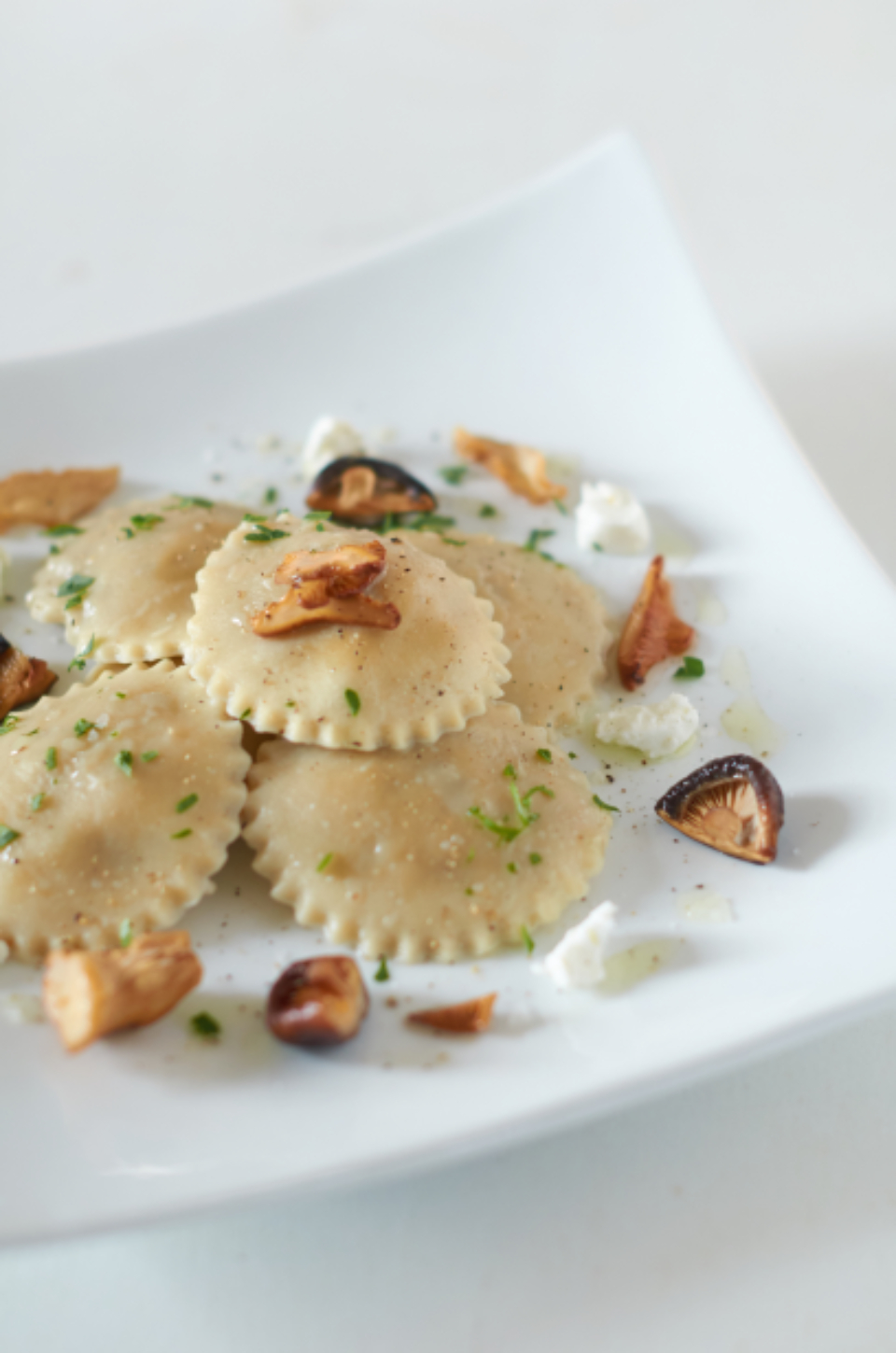 Hausgemachte Teigtaschen mit gebratenen Pilzen und Ziegenfrischkäse